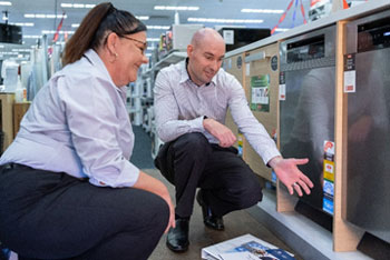 Two people looking at dishwashers